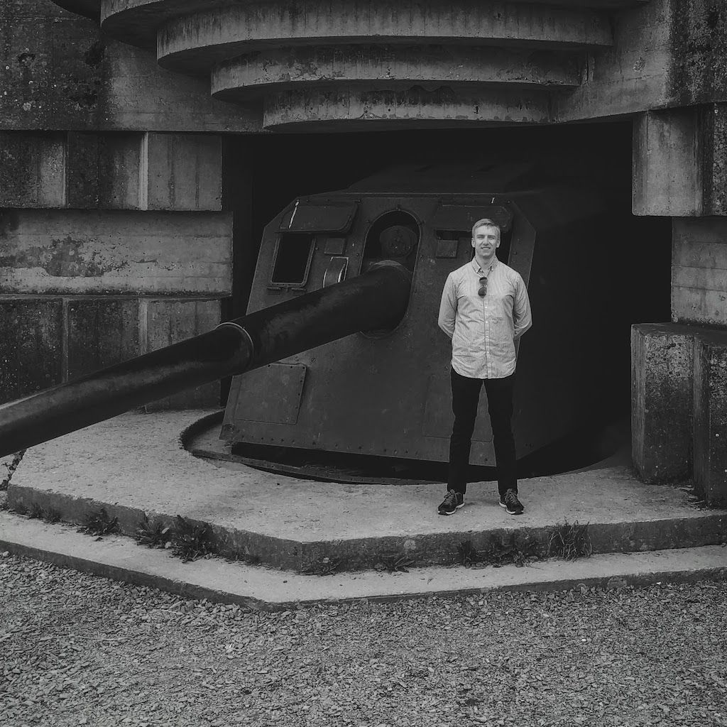 Alex standing next to a World War II battery cannon in Normandy